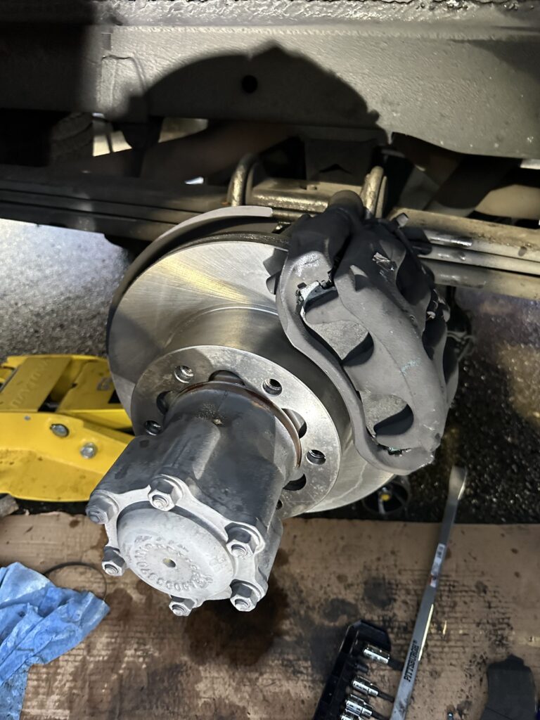 Commercial truck brake rotor and hub exposed during a mobile brake inspection