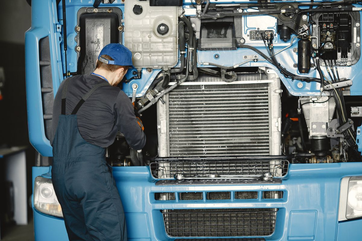Mechanic inspecting a commercial truck engine and cooling system